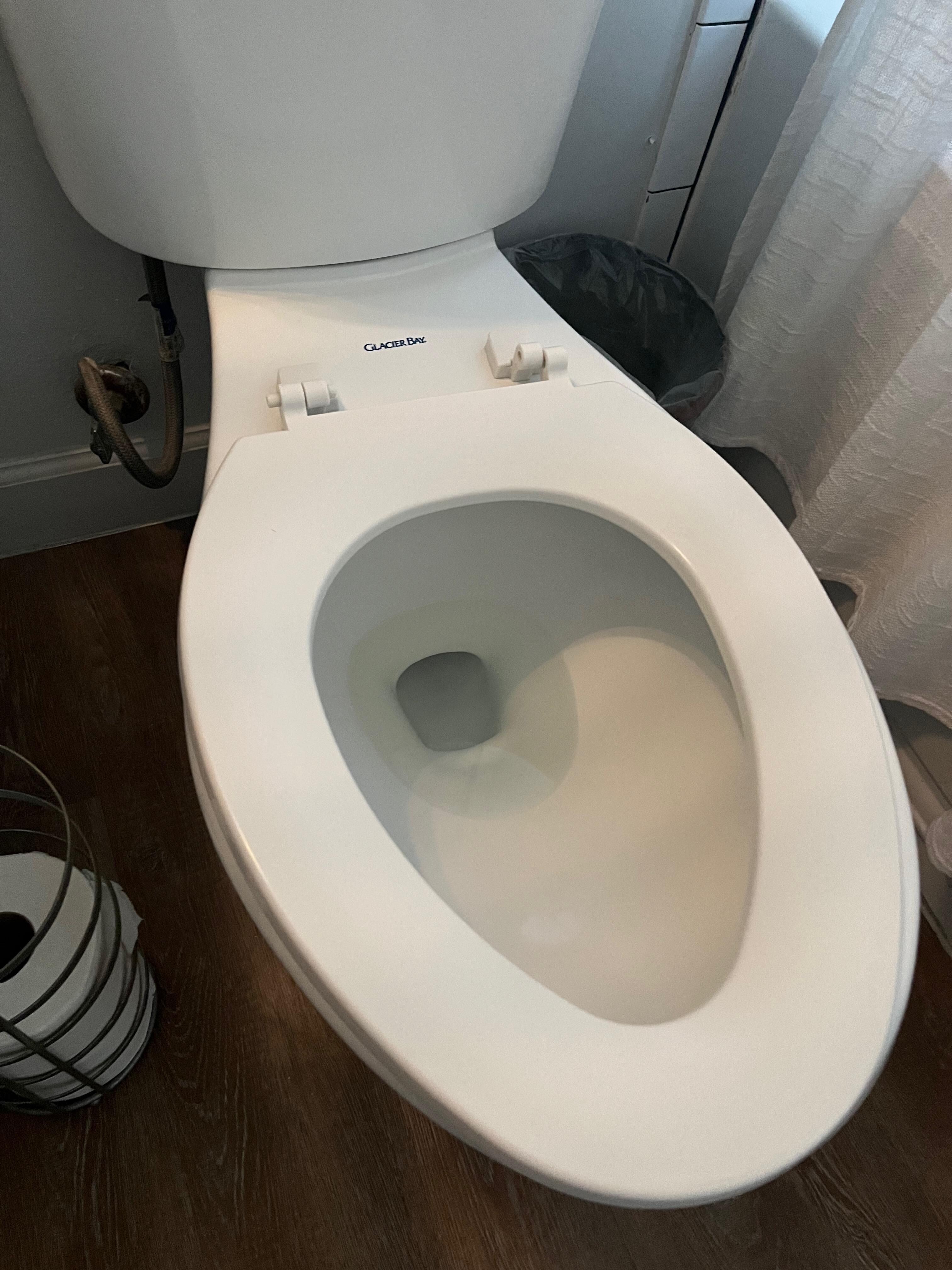 Two bathrooms with broken toilet seats