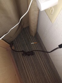Half smoked cigarette behind end table