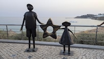 Sculptures at top of escalator along coast line.