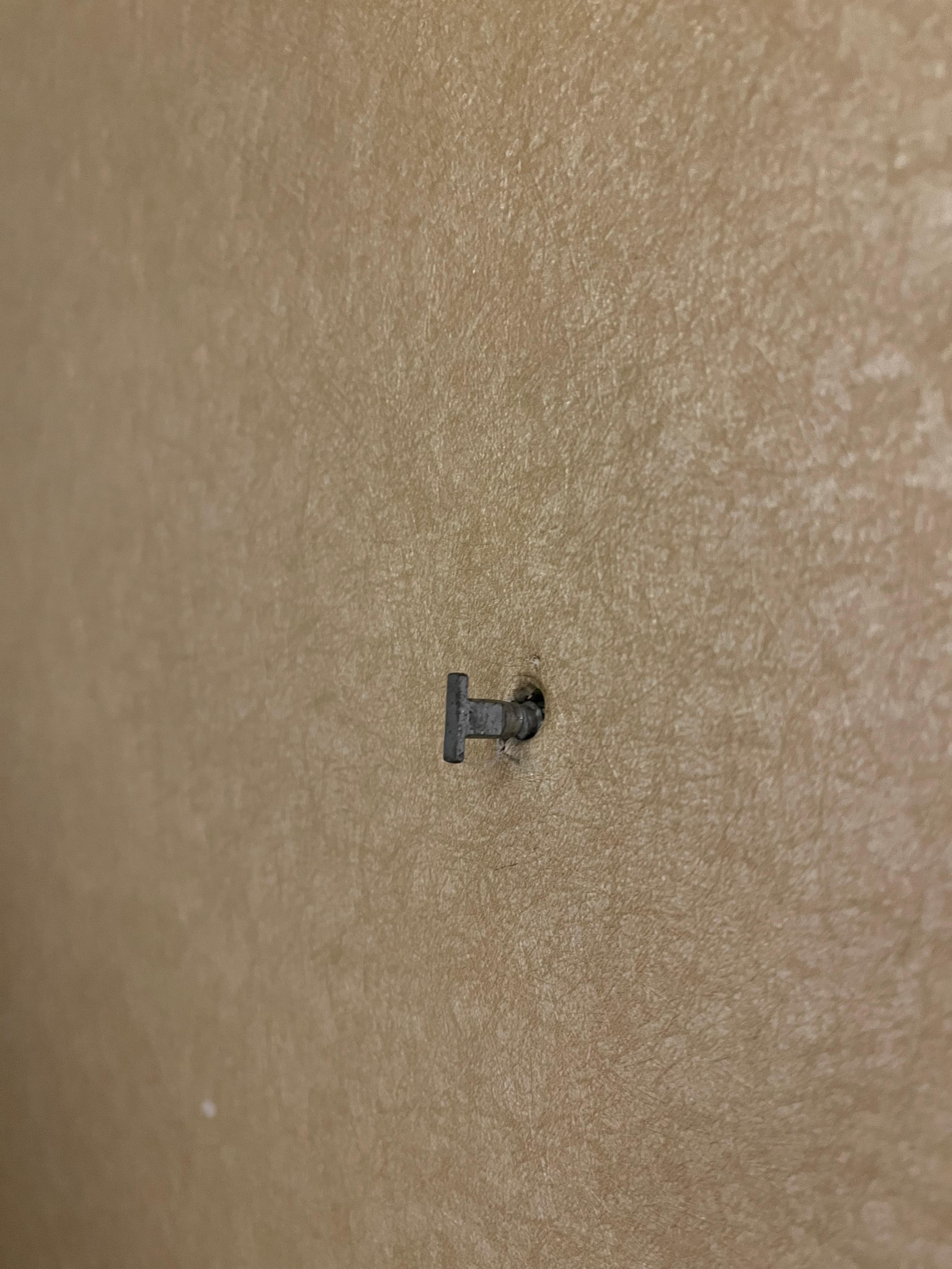 Metal piece in wall next to bed 