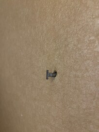 Metal piece in wall next to bed