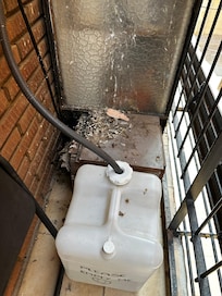 Air con bottle outside with bird poo all over it