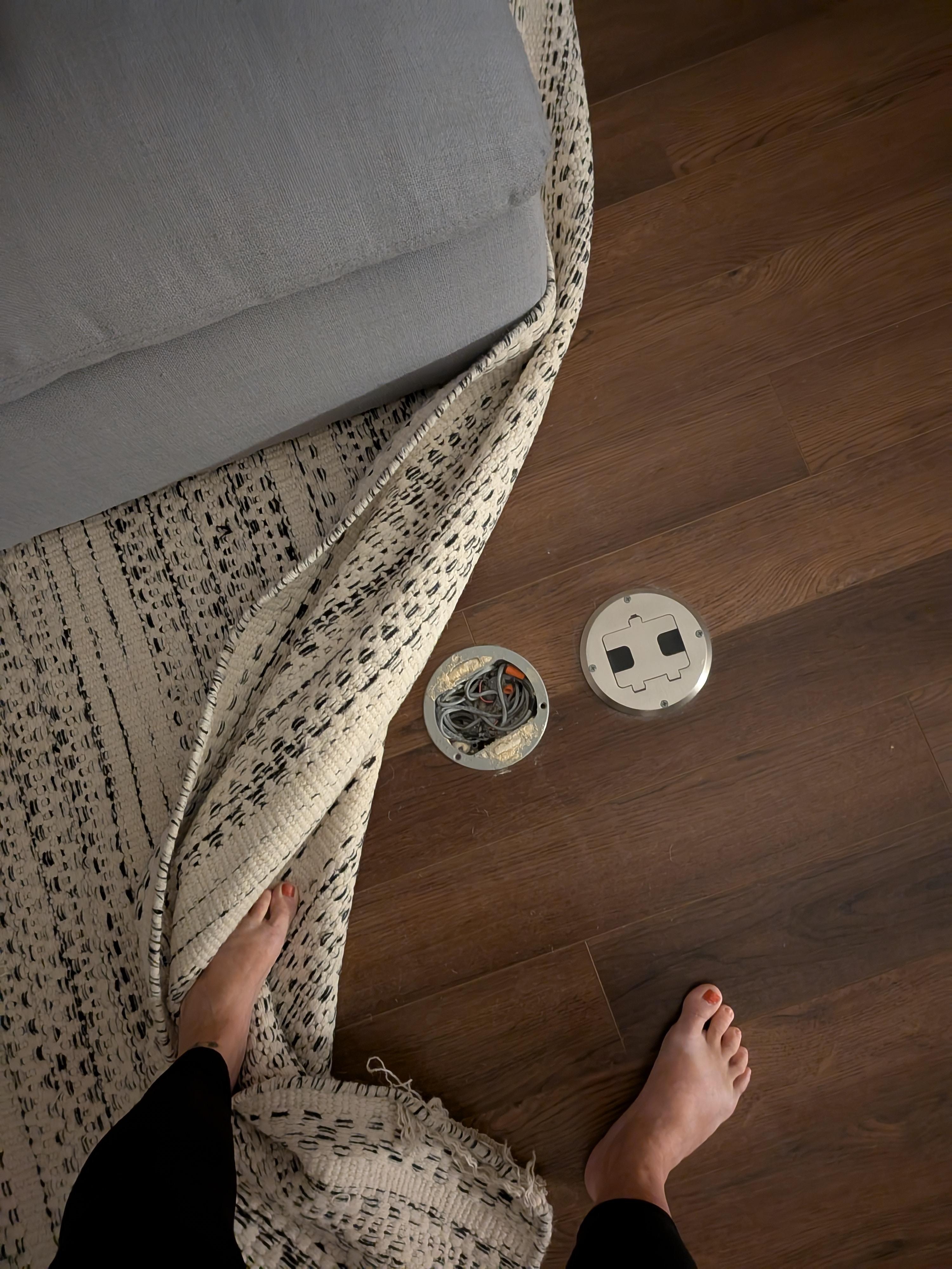 Uncovered electrical outlet in floor under rug 