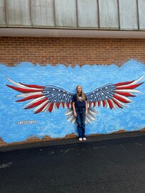 Stand with painted Deaf Eagle wings open wide on the brick wall so CQQL and neatly.