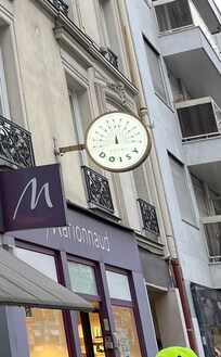 This sign on the boulevard is the only clue. The entrance is down and alley to the side.