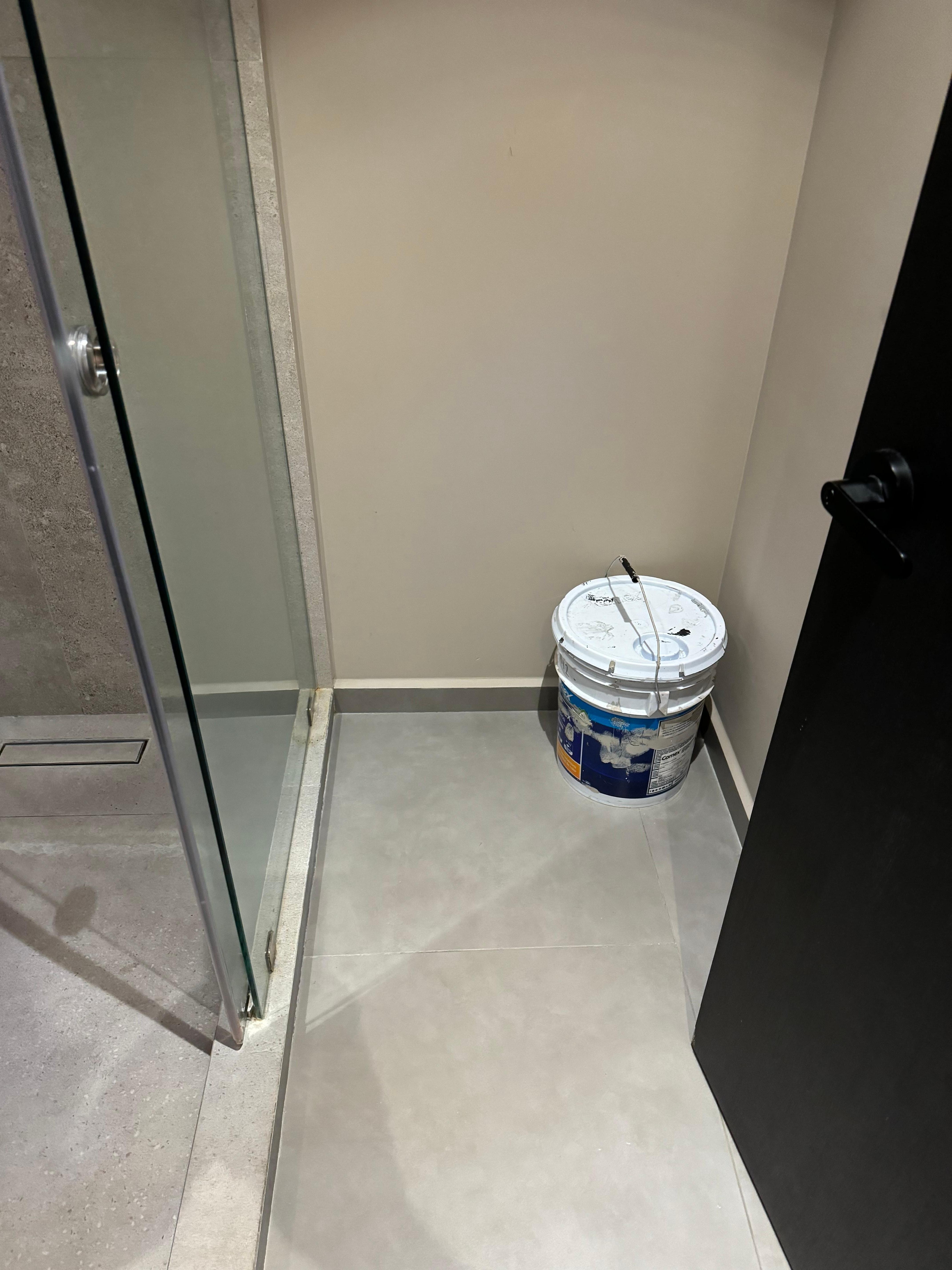 Empty bucket of paint left in the bathroom