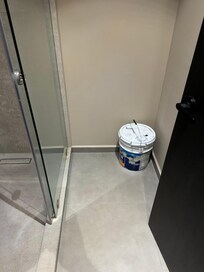 Empty bucket of paint left in the bathroom