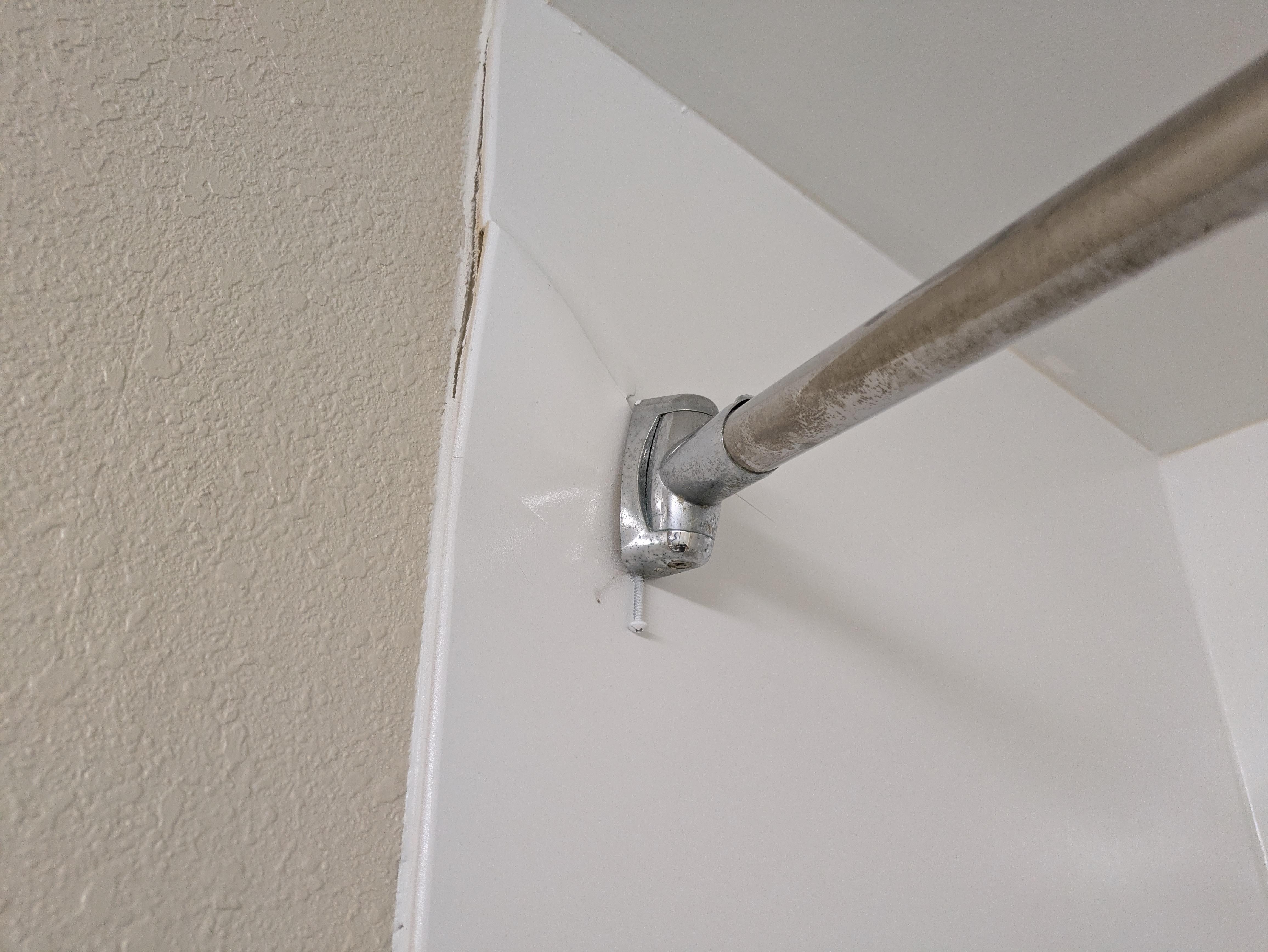 Shower stall and curtain rod not properly secured.
