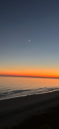 Sunset with a crescent moon rising.
