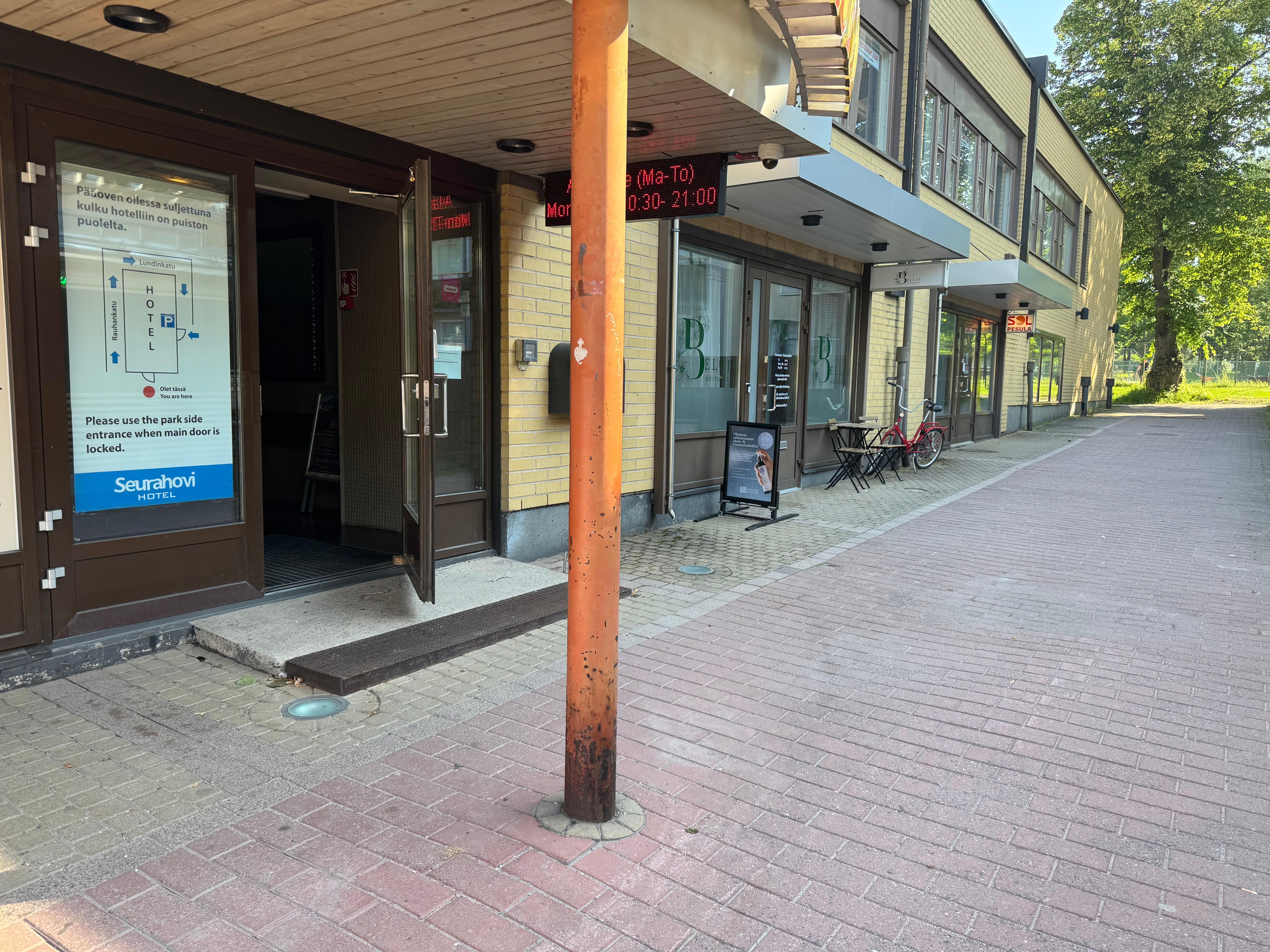 The entrance is actually on the side of the building, but it takes you into that spiral staircase that goes up to the restaurant. Your room code opens the door at the back of the building that will get you to the elevator with minimal stairs.