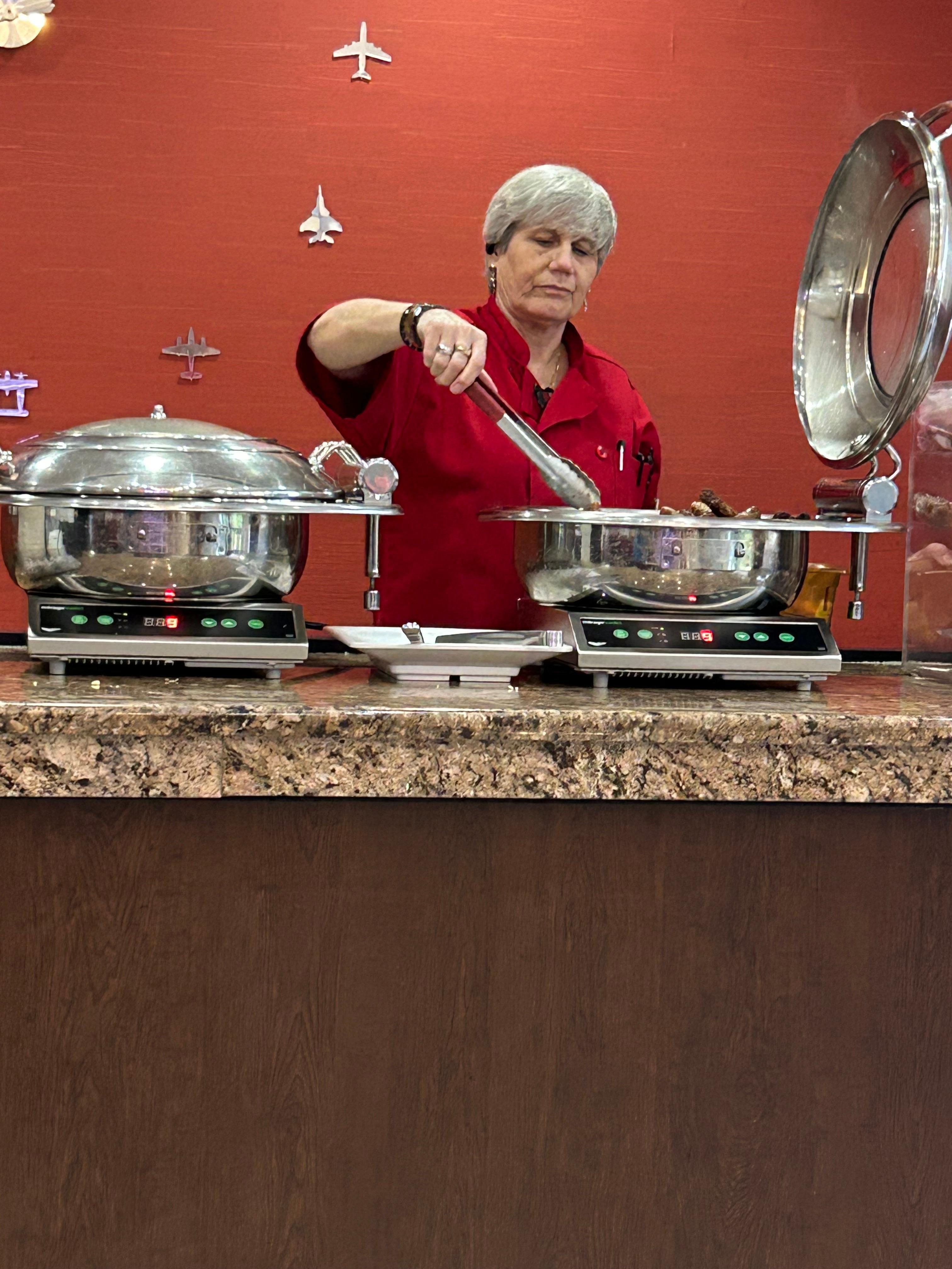 Staff never wore gloves but continued to refill the food, fold the boxes and put them in the garbage then immediately returned to refill more food never wore gloves never washed her hands 