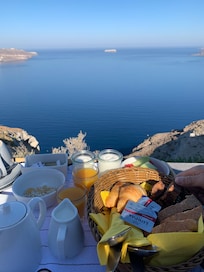 Petit déjeuner au bord de la piscine avec une vue époustouflante sur la caldeira.