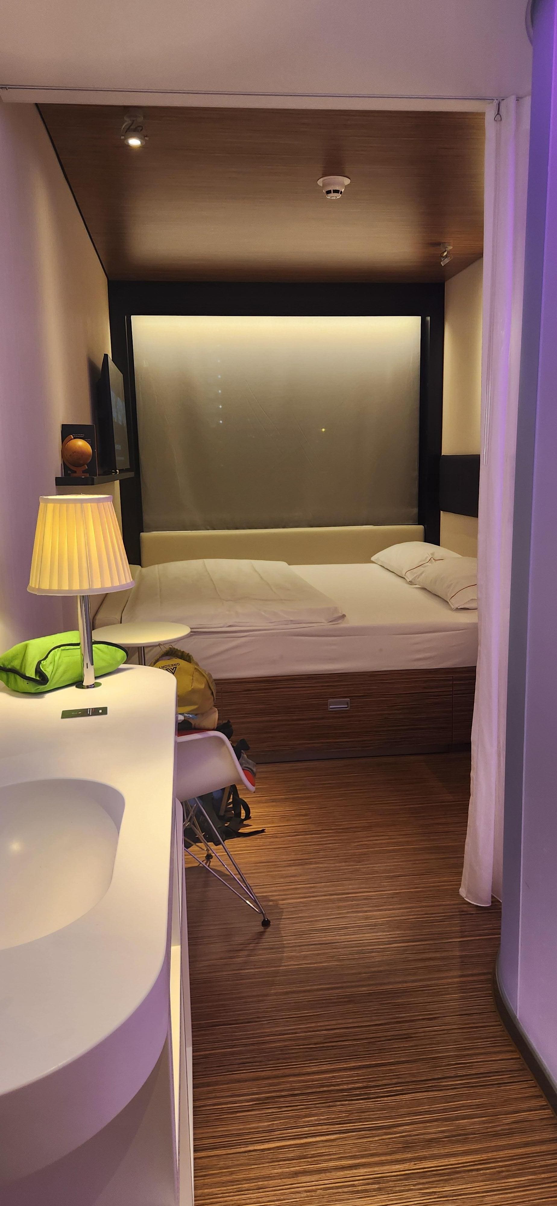 king size bed, full shower and toilet to the right, narrow sink to the left.