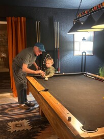 Grandpa teaching Christopher how to hold a pool stick!