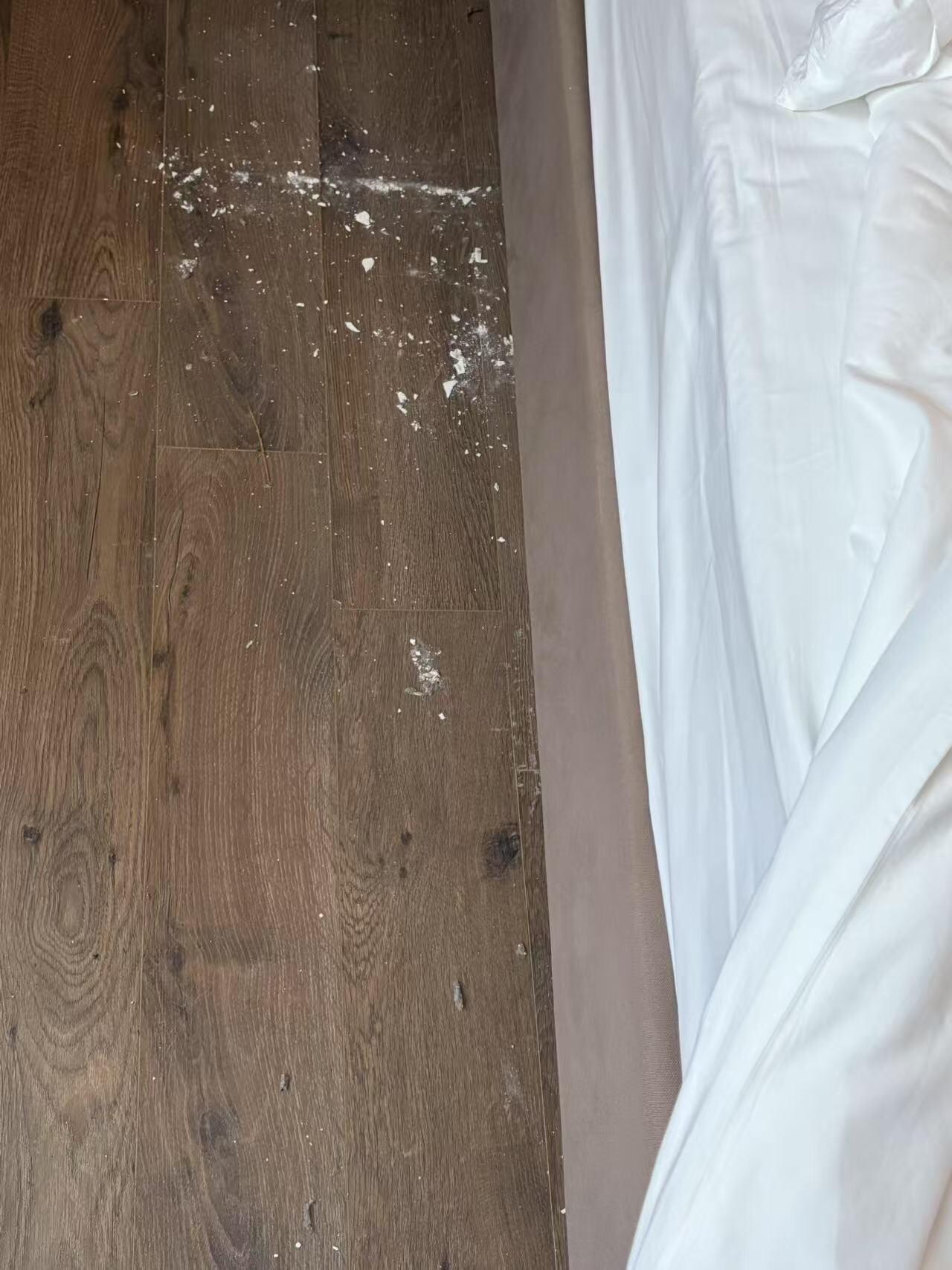 Floor is dirty beside the bed