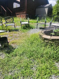 Fire pit area with weeds over the blocks and chairs