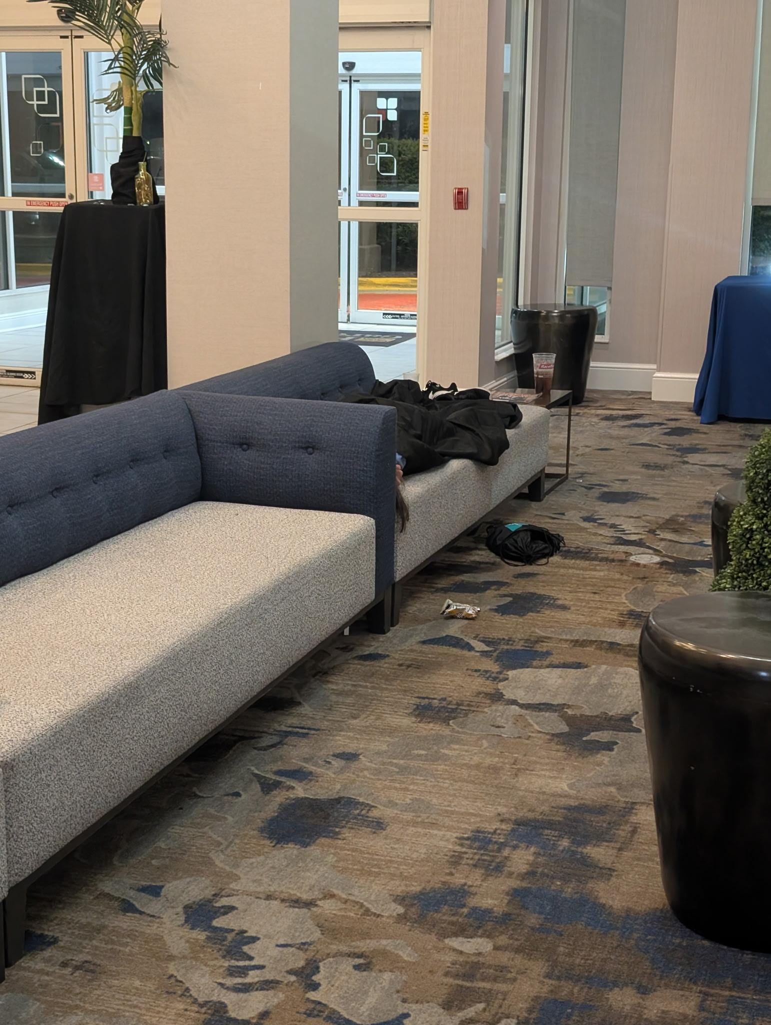 Homeless person asleep in the hotel lobby.