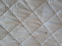 Mattress and sheets dirty with hair and stains on sheet and mattress