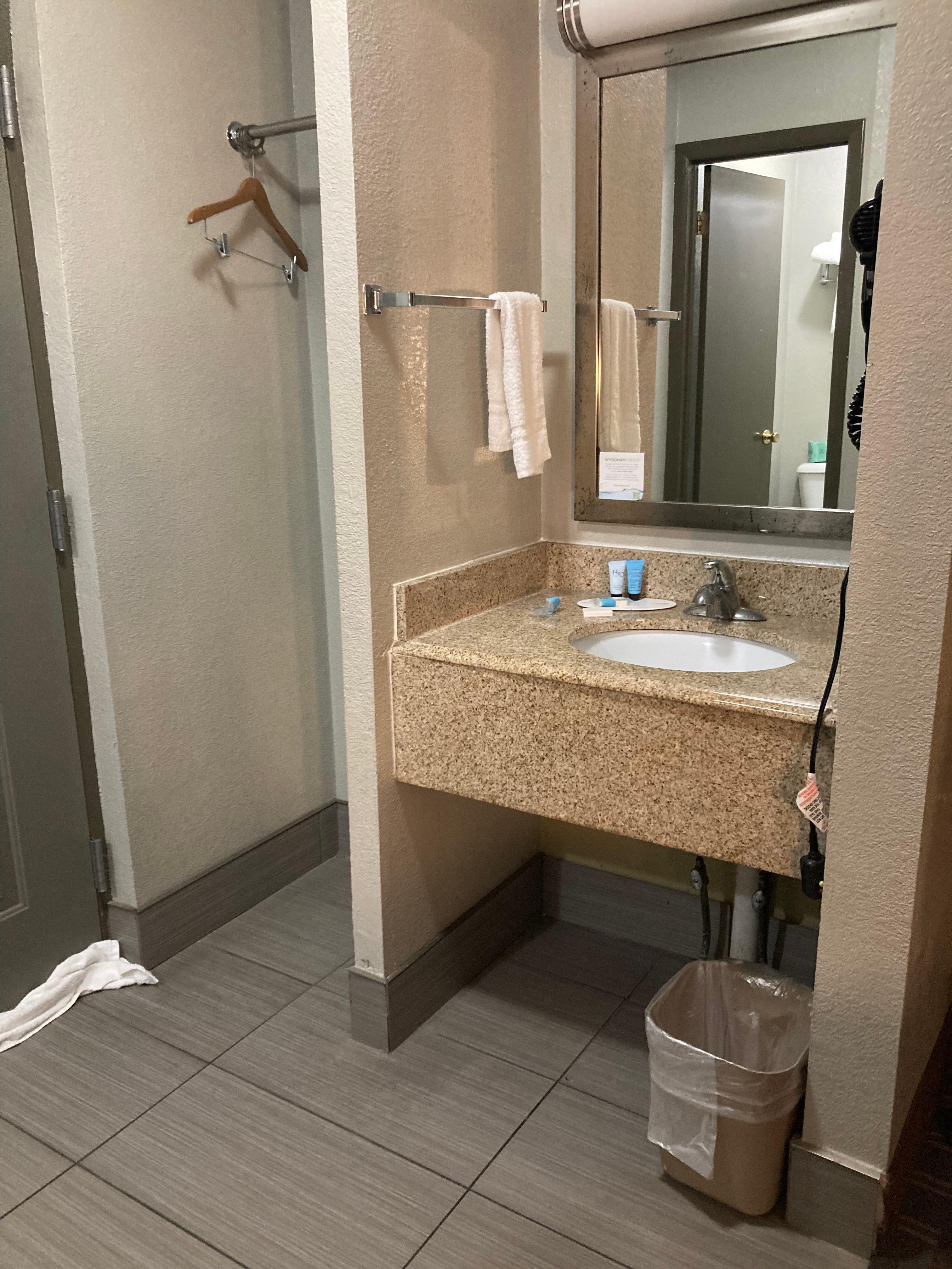 Bathroom sink next to front door of hotel room. 
