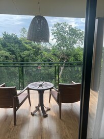 View from room with patio overlooking river and small waterfall.