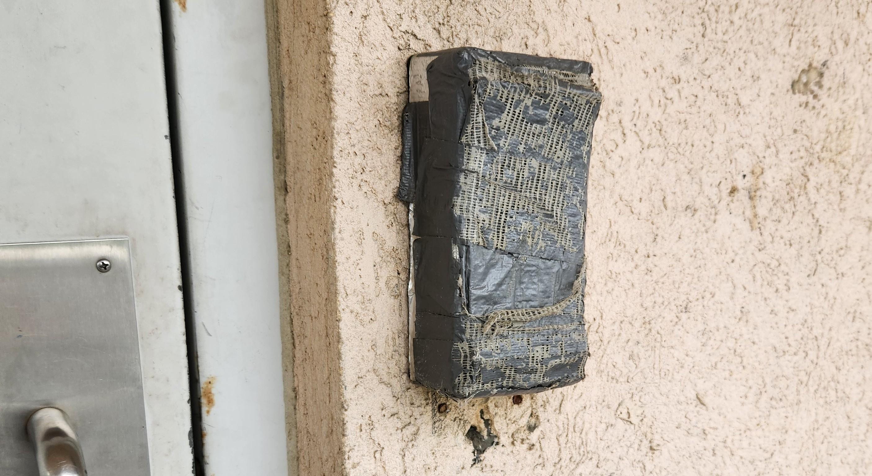 The electronic lock has been taped over for so long that the tape has weathered thru to its inner fabric threads.
