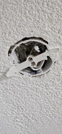 Open faced electrical box with exposed capped wires - close view.