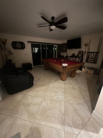 The area with the pool table just behind the kitchen.