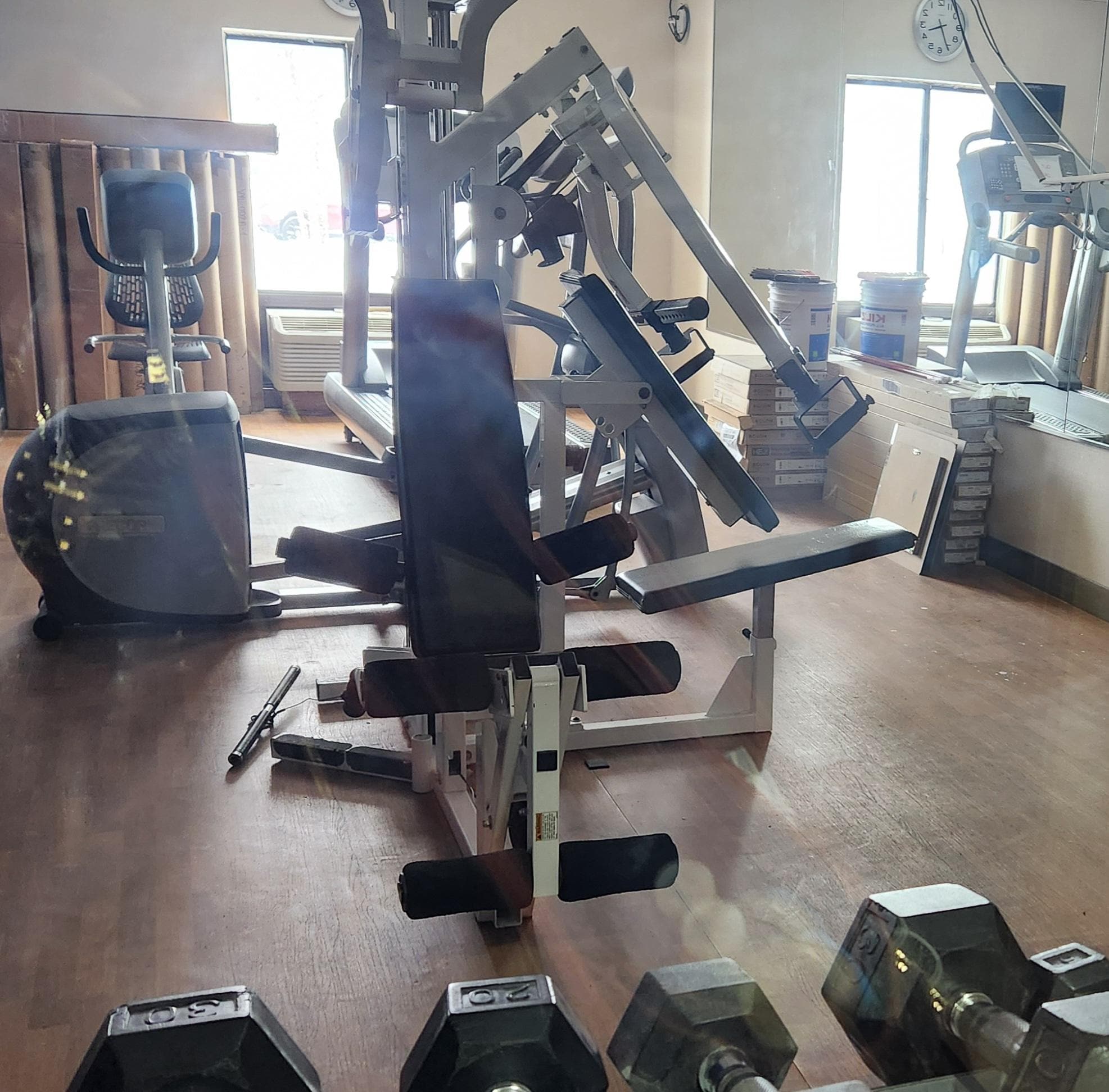 Closed gym has construction materials near mirror 