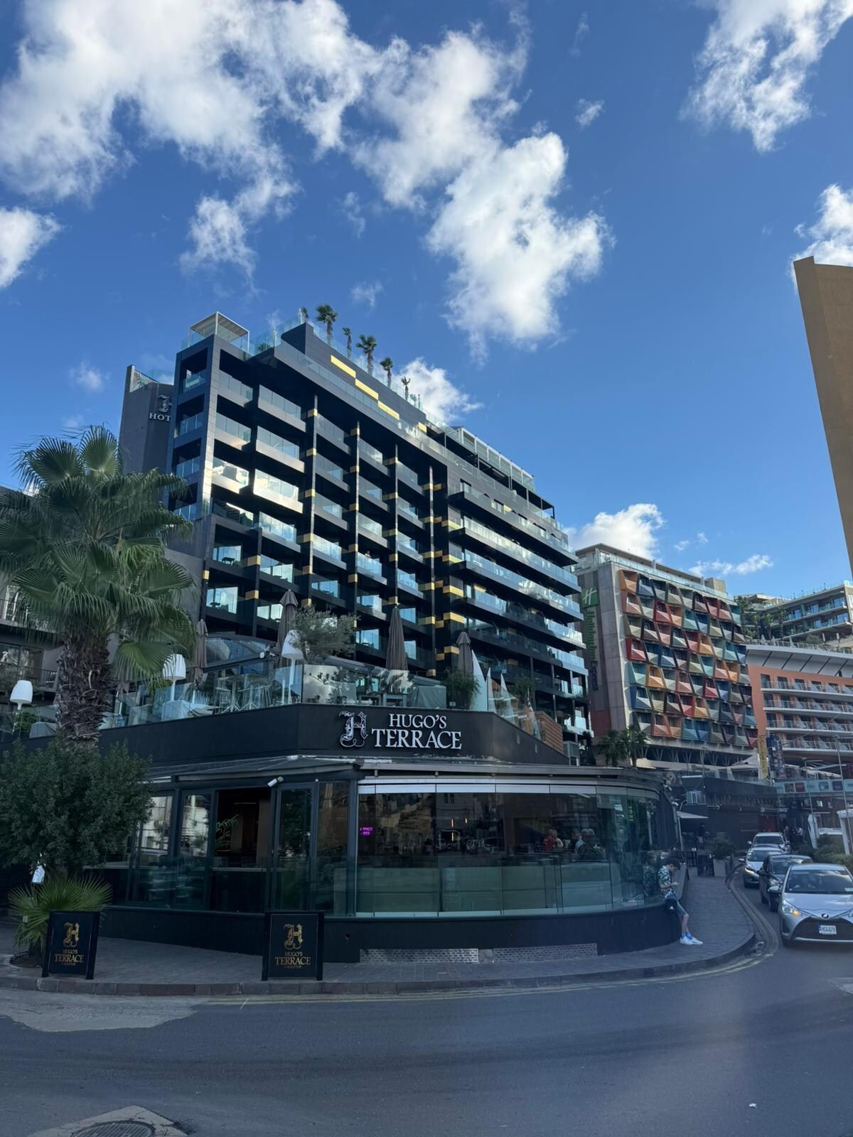 Hotel von außen, davor die zugehörige Bar, die gegenüber vom Hotel ist.