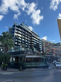 Hotel von außen, davor die zugehörige Bar, die gegenüber vom Hotel ist.