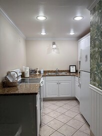 Kitchen: electric stove, dishwasher, sink, mini coffee maker, freezer fridge