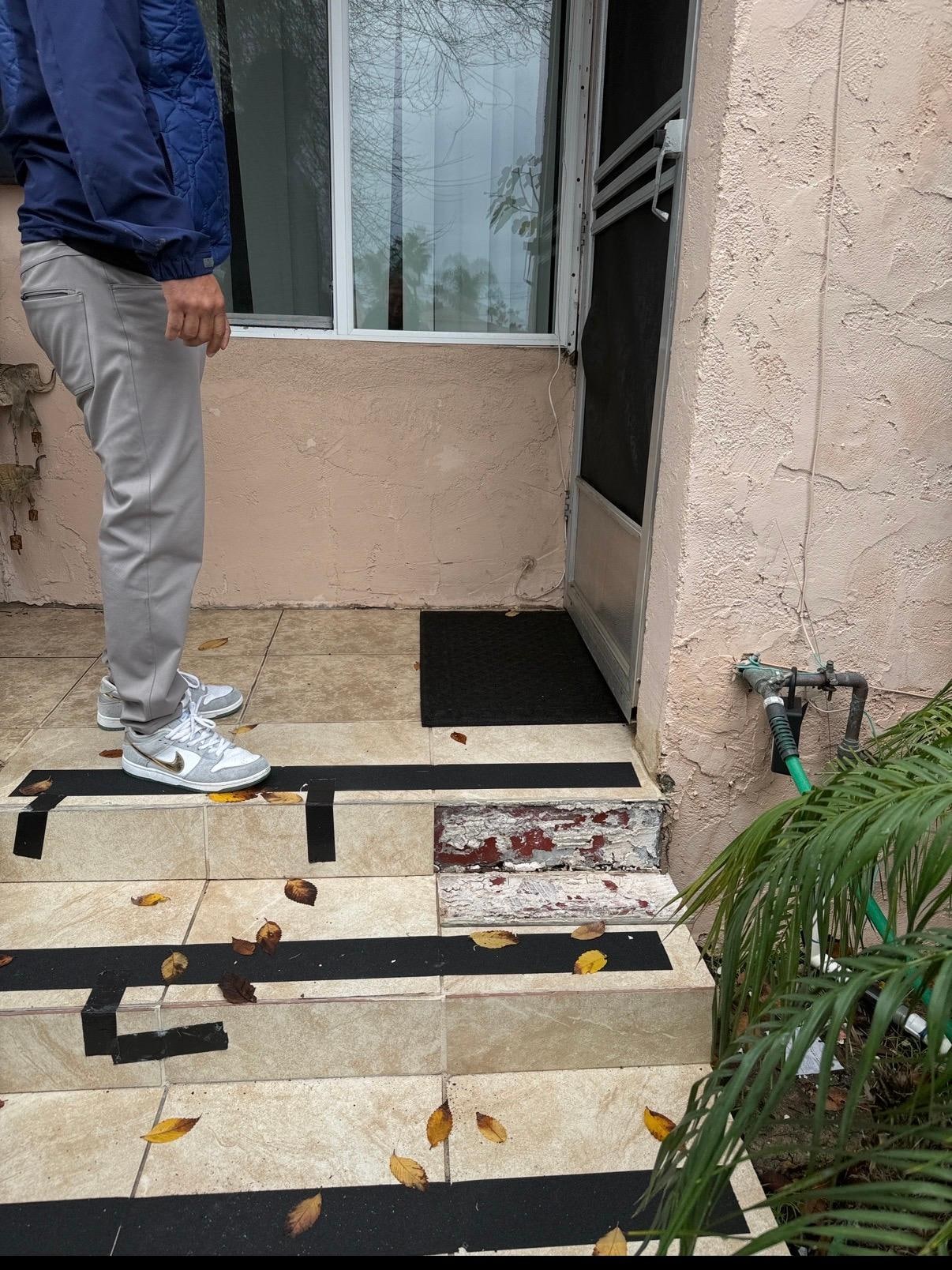 Stairway to front door was held together by duct tape! Tiles also broken.