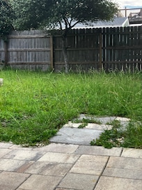 Grass on property & neighbors privacy fence(not a full fenced yard). More false advertising we felt