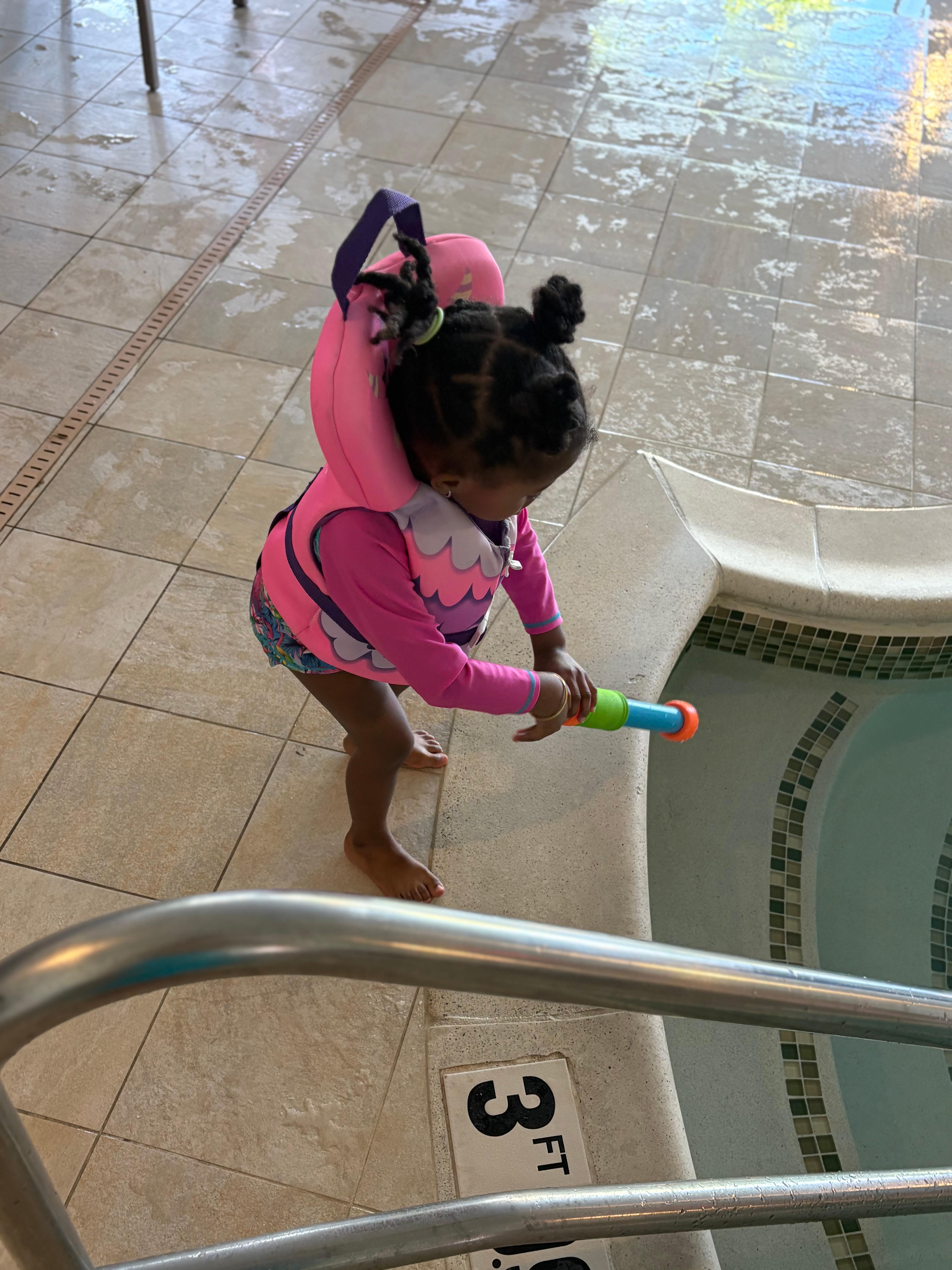 3 year old daughter playing in pool 