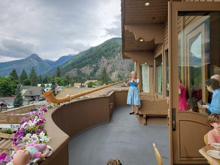 alpenhorn player on balcony during breakfast