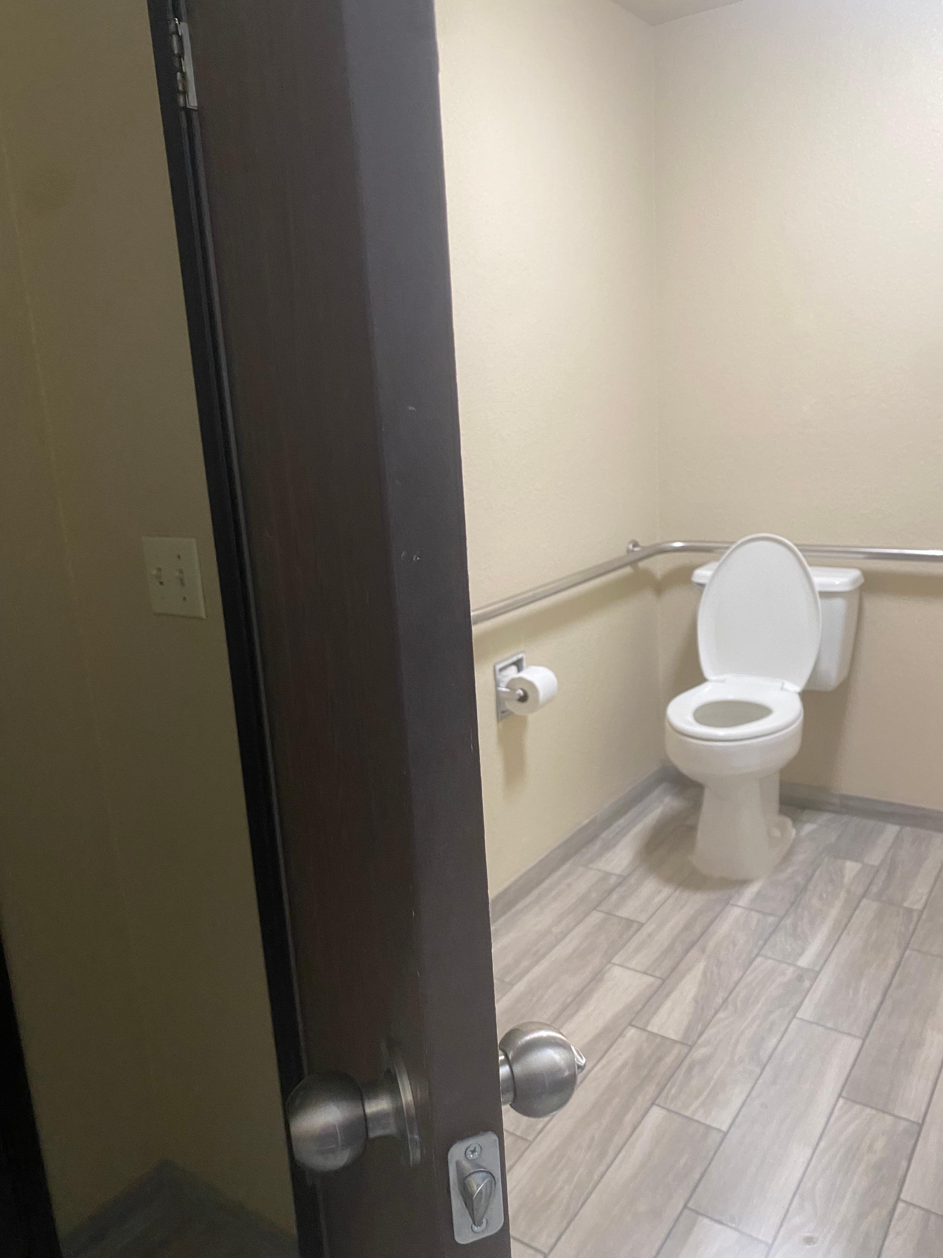 Light switches behind the door outside of the bathroom.