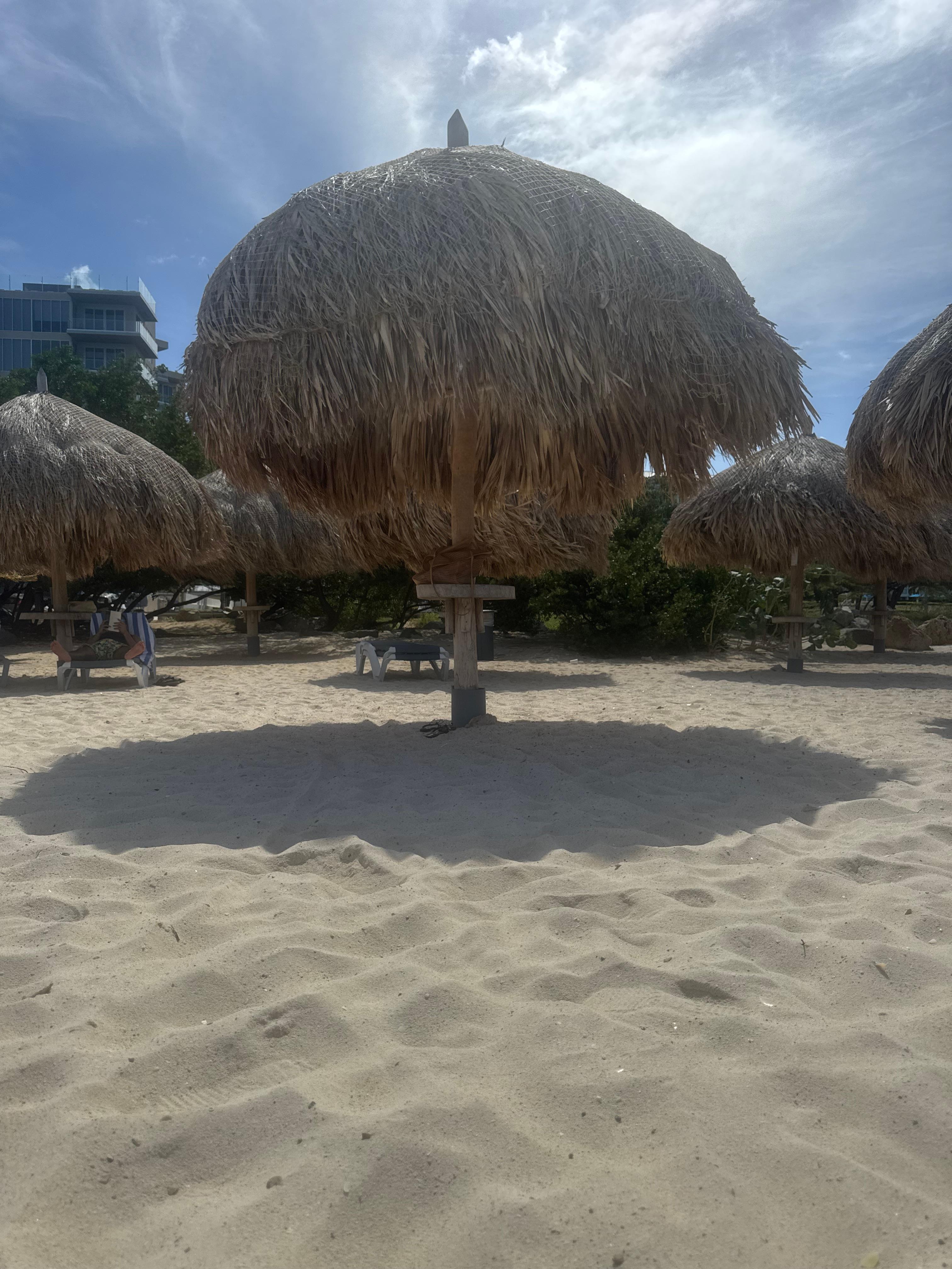 Free Tiki umbrellas and loungers for hotel guests on private beach.