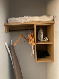 An ironing board, iron, hangers and a blow dryer for guests.