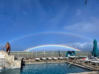 The photo of the double rainbow was taken from the pool. Light showers came down from the mountains behind us.