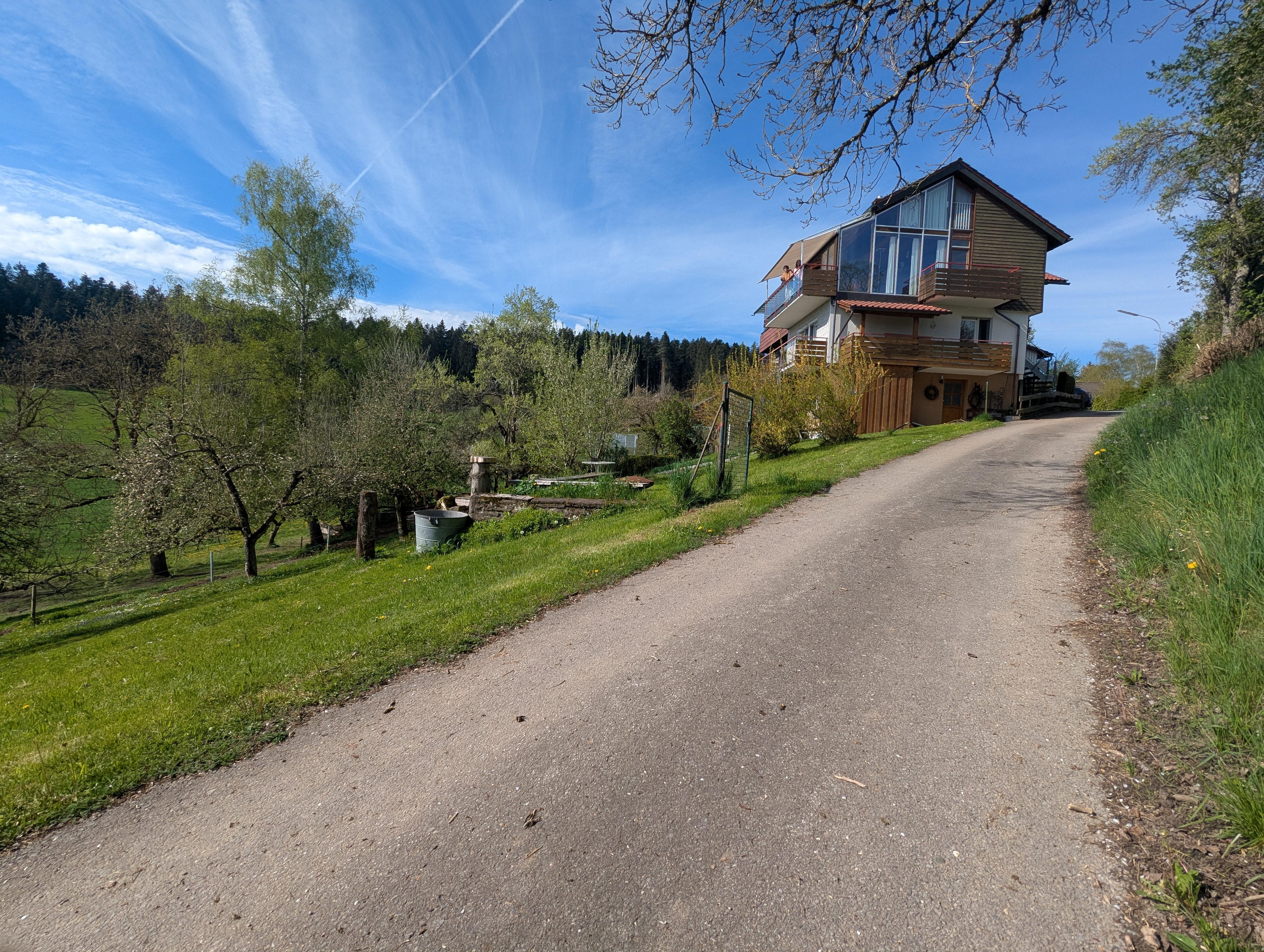 Vue de la maison de loin depuis le petit sentier dans la foret