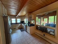 Very roomy kitchen with enclosed screened porch thru the window.