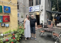 Hosts Natalia & Alexy on the patio (on a grey day :-() in their colourful and welcoming Art Inn Space in the Kazimierz quarter of Krakow, Poland 2025.