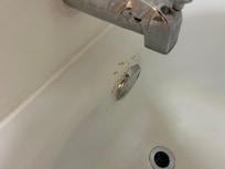 Rust and grime in bathtub. Tub fills while showering from faulty faucet.