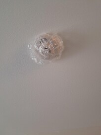 Smoke detector covered with plastic in room.