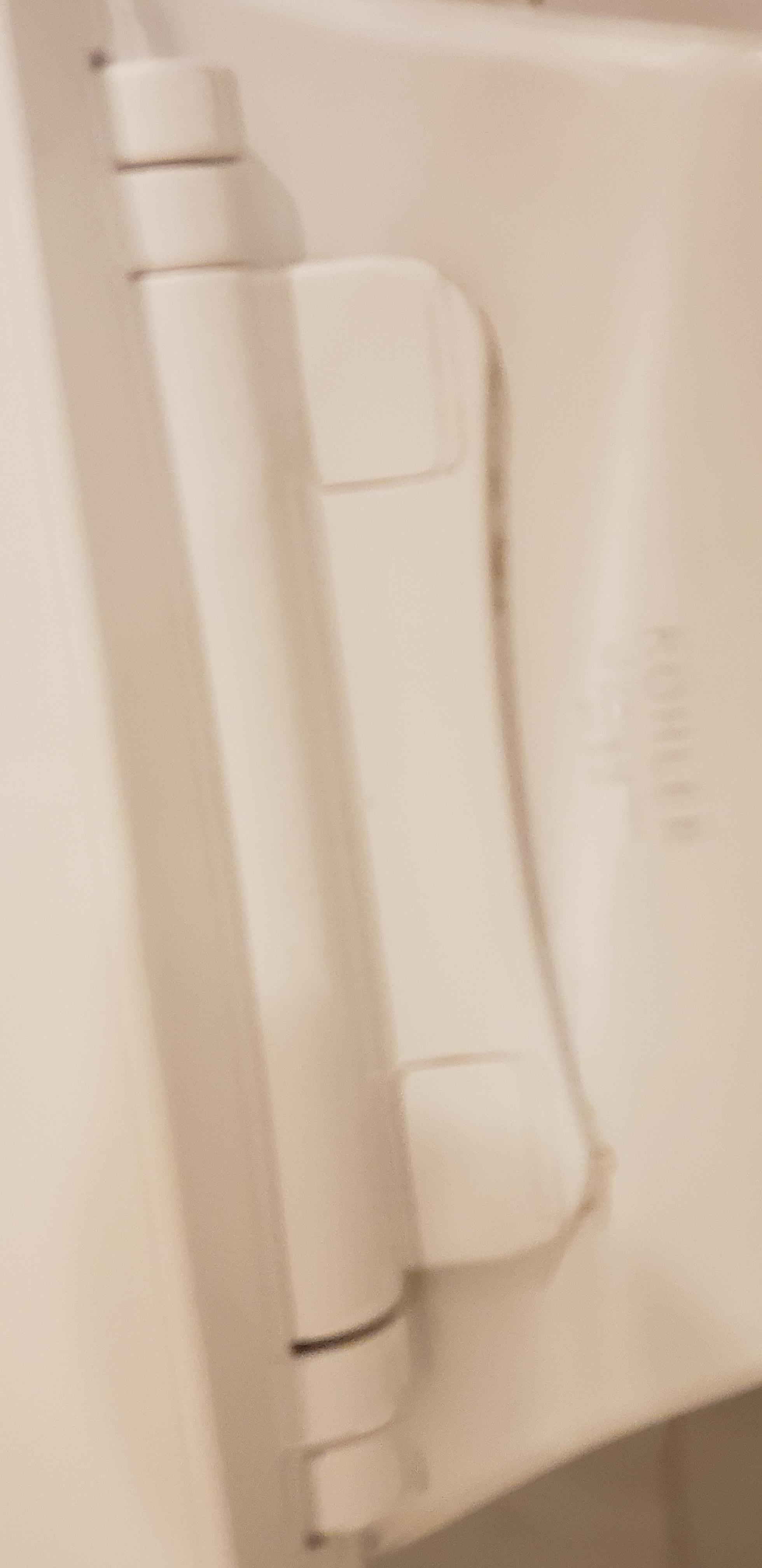 Yellow on back of toilet behind hinge