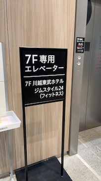 Elevator sign by Seven Eleven on the second level of the building.