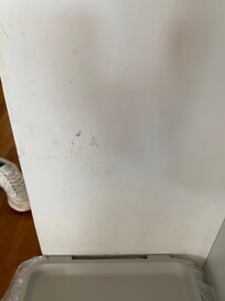 Dirt on wall above garbage can