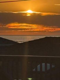 Sunset view of ocean from rooftop deck.