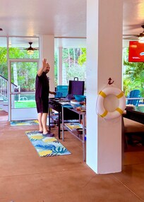 Under-deck screen porch with stone top grill, seating & large tv, and large tiki bar (not in picture)