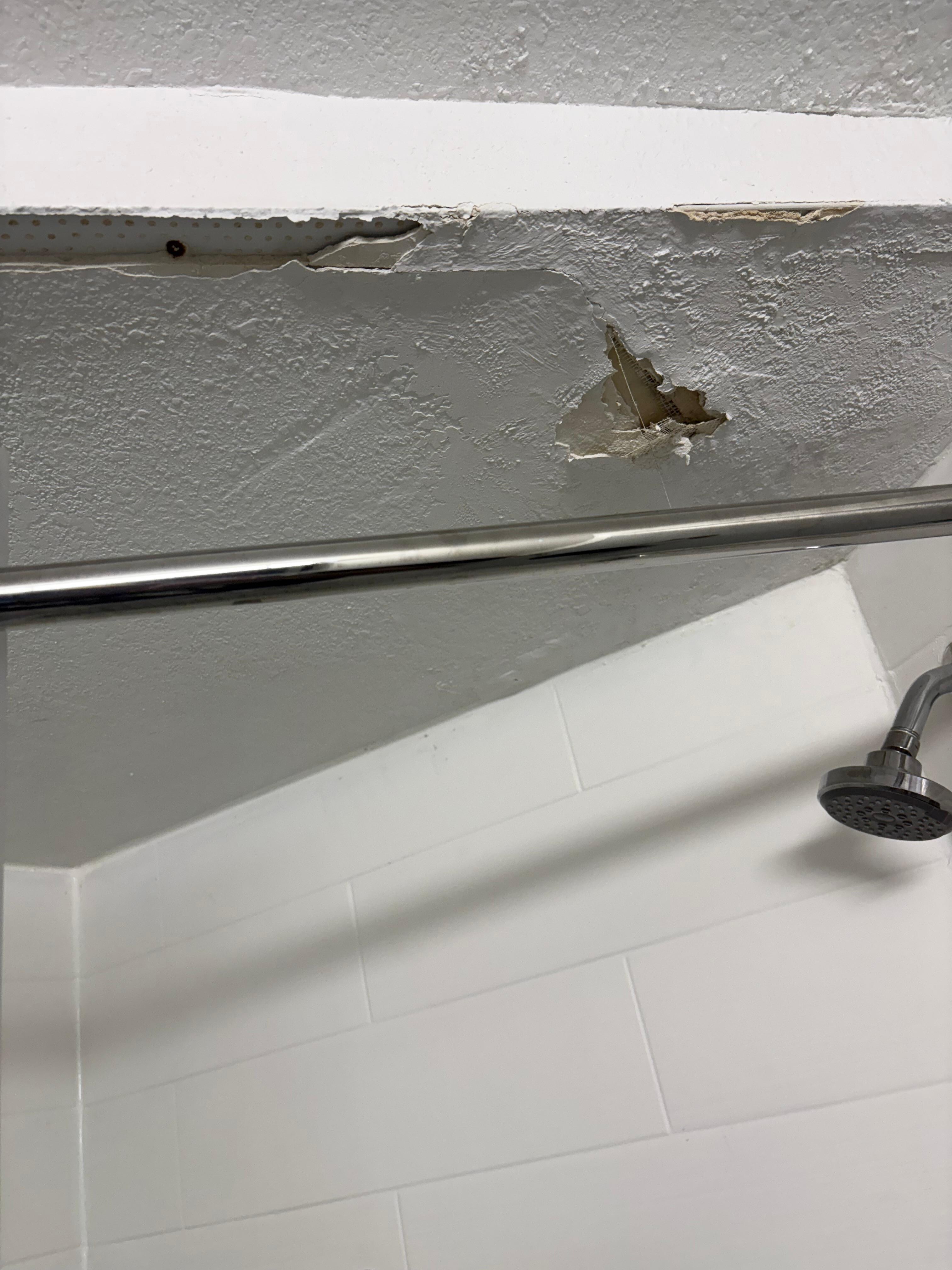 Hole in bathroom wall by the shower